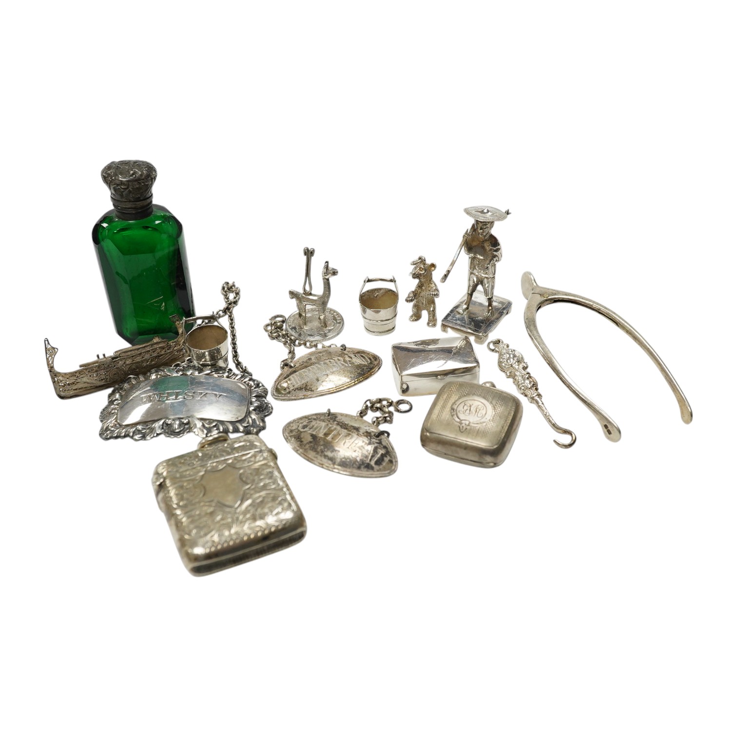 Sundry small silver including a vesta case, two wine labels, mounted glass scent bottle, wishbone sugar nips, sovereign case, etc. and a plated wine label. Condition - poor to fair to good